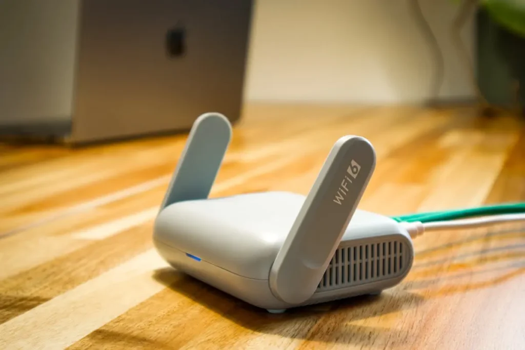 Router WiFi dengan antena di atas meja kayu